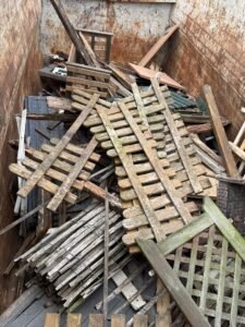 Außenholz wie Zaunteile, Latten und Gitter getrennt im Container gesammelt
