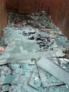 Glasscherben und Flachglas im Container: getrennte Entsorgung bei einer Entrümpelung in Frankfurt