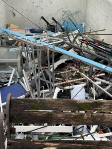 Metallschrott wie Regale und Gestelle im Container, getrennt gesammelt für die Verwertung