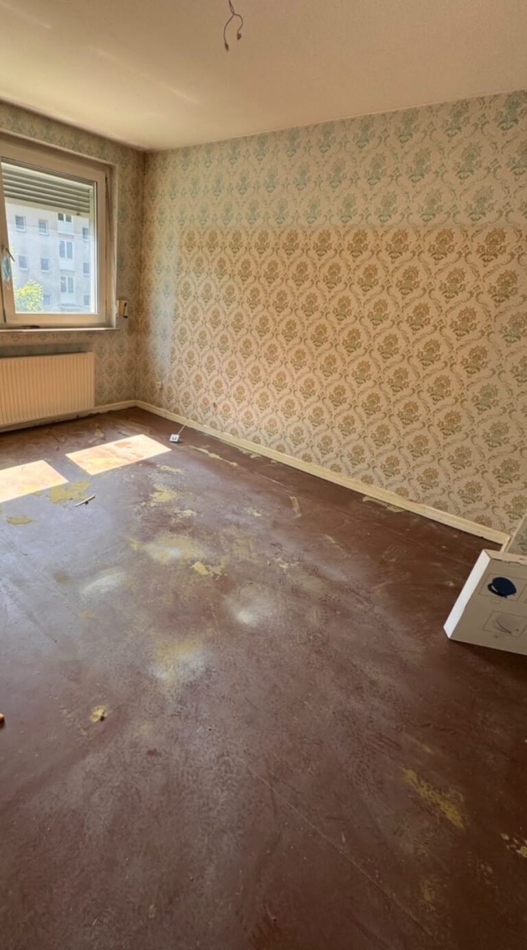 Haushaltsauflösung nachher: leeres Wohnzimmer, Teppichboden entfernt und Vorhänge abgenommen